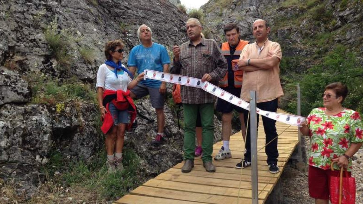 El alcalde de La Pola y el pedáneo de Ciñera inauguran la nueva pasarela peatonal.