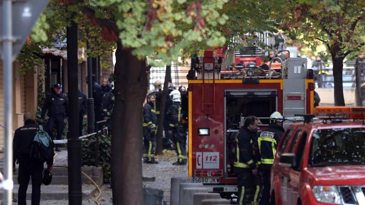 Bomberos y agentes de la policía junto al edificio en el que tuvo lugar un incendio. PEPE TORRES
