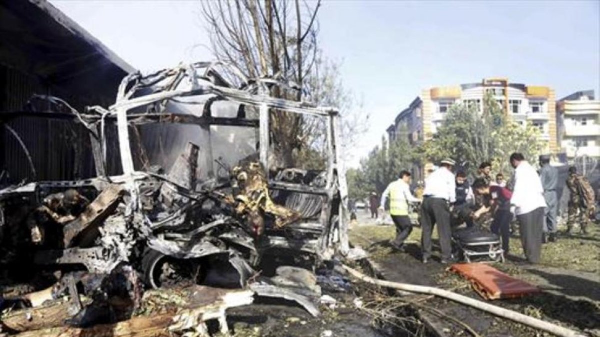 Rescate de víctimas entre los restos calcinados del autobús atacado en Kabul