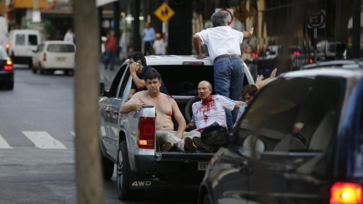 Efraín Alegre, líder del Partido Liberal (izquierda), junto a un herido en los disturbios de la madrugada del sábado en Asunción.