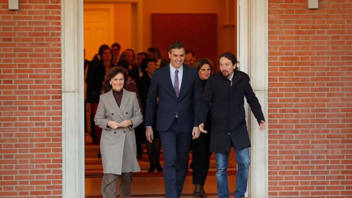 El presidente del Gobierno, Pedro Sánchez (c), camina junto a la vicepresidenta primera y ministra de Presidencia y Relaciones con las Cortes, Carmen Calvo (i), y al vicepresidente de Derechos Sociales y Agenda 2030, Pablo Iglesias (d), momentos antes de posar para una foto de familia del nuevo gabinete de ministros en el Palacio de la Moncloa antes del primer Consejo de Ministros celebrado este martes.