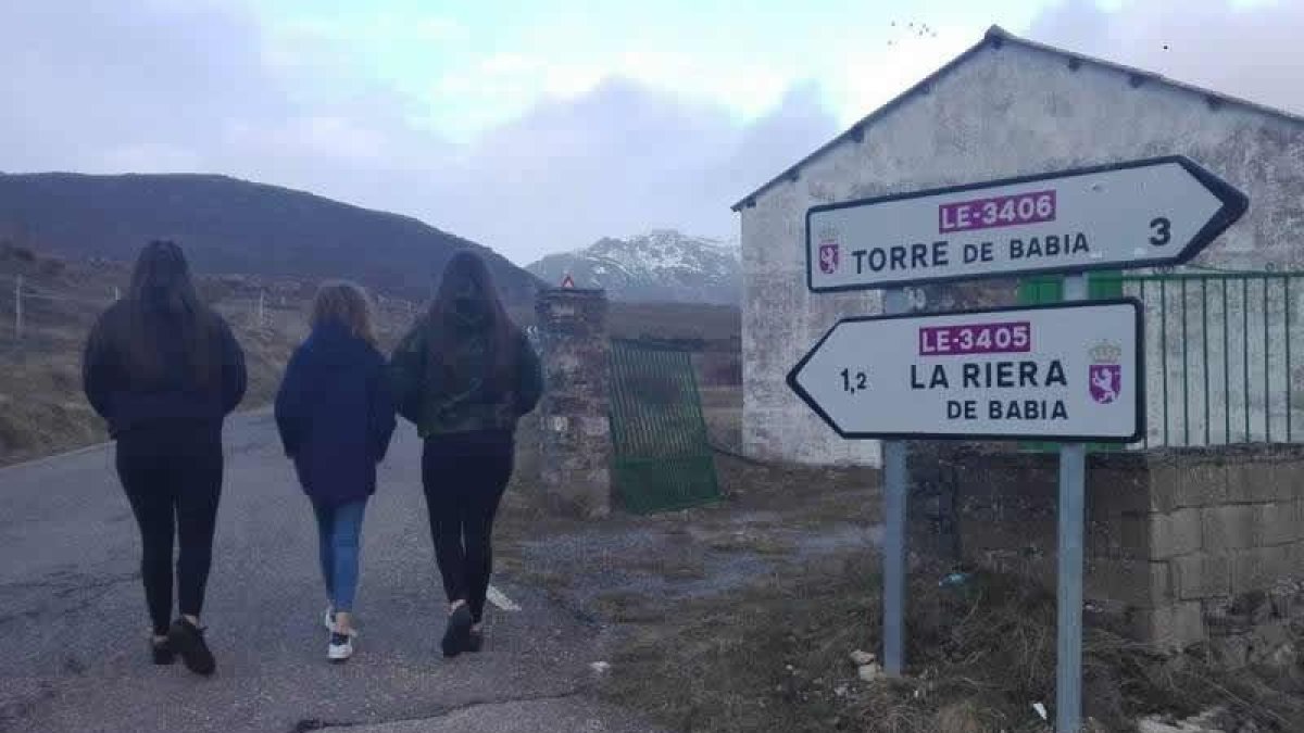 Las tres alumnas tienen que recorrer dos kilómetros a pie por una carretera de montaña para llegar al punto donde las recoge el transporte escolar.