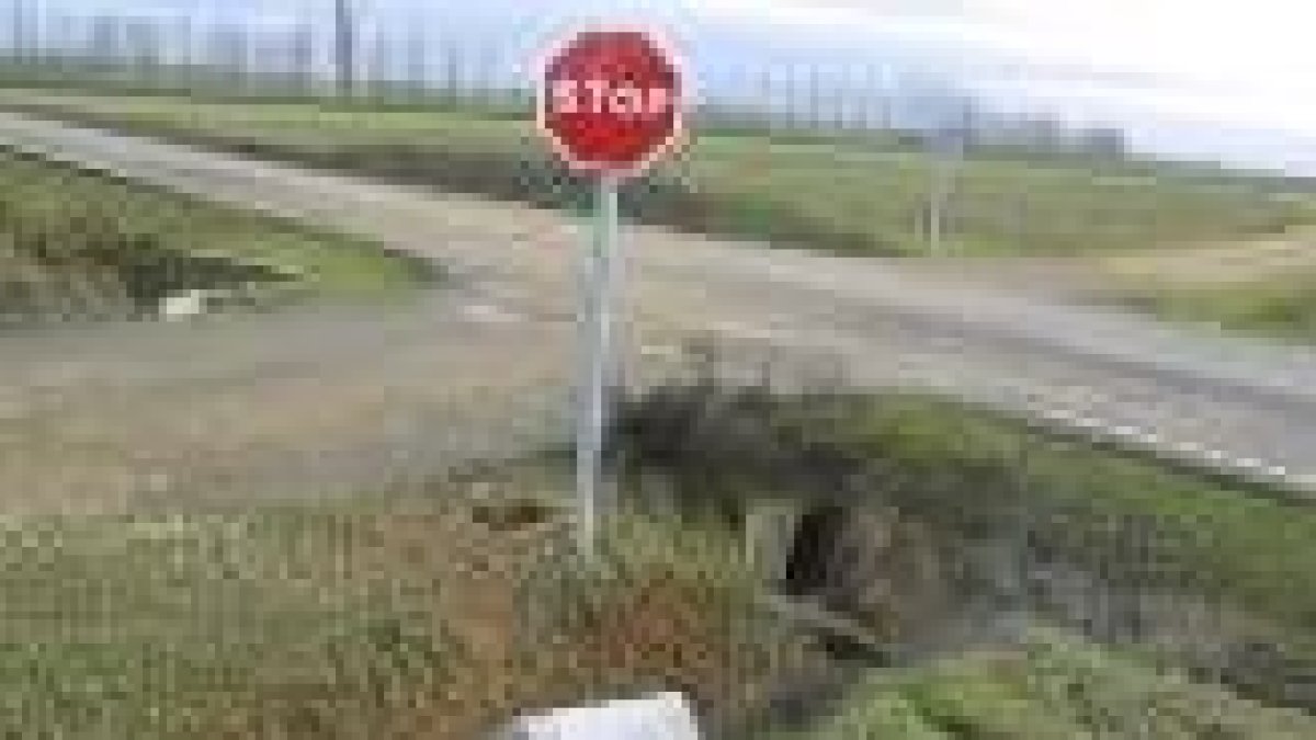 El mojón permanece tirado en el reguero próximo a la carretera desde hace más de un año
