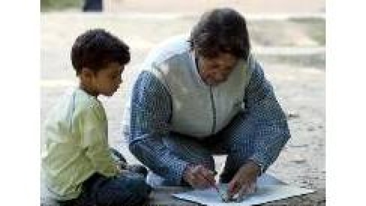 Una abuela enseña a su nieto a pintar durante un certamen de pintura