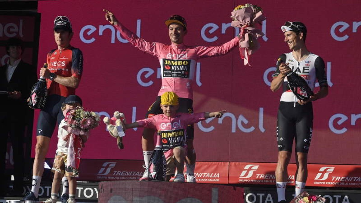 Roglic escoltado en el podio por Thomas y Almeida. ANTIMIANI