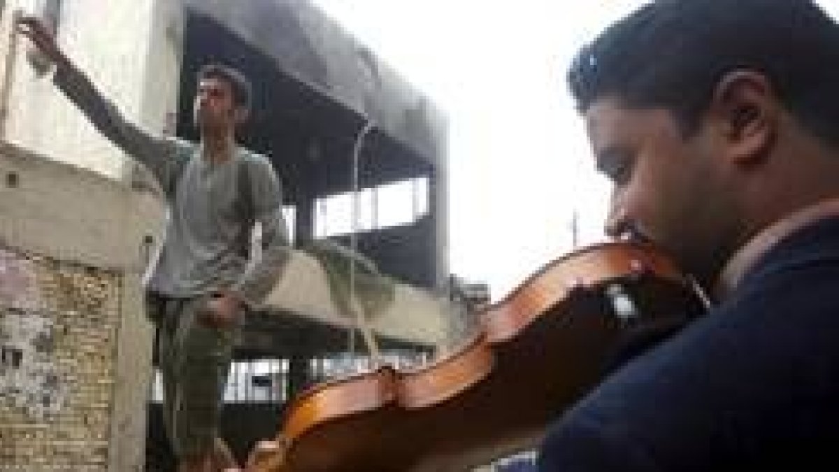 Un alumno de la Escuela de Arte de Bagdas ensaya en la calle, entre las ruinas de la guerra