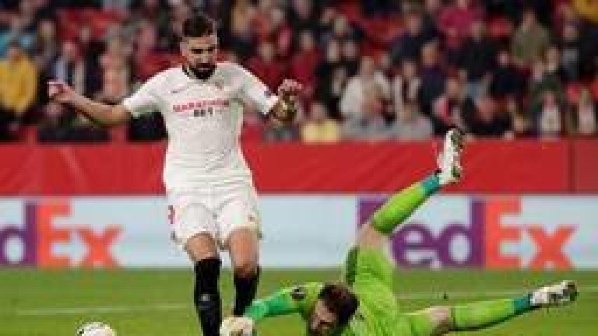 El centrocampista del Sevilla Munas Dabbur trata de superar al portero Asmir Begovic, del Qarabag. JULIO MUÑOZ