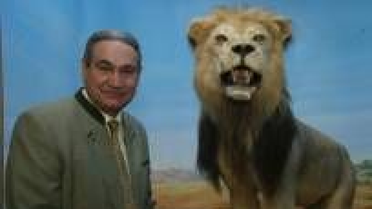 Eduardo Romero Nieto posa junto a uno de los de los leones del museo