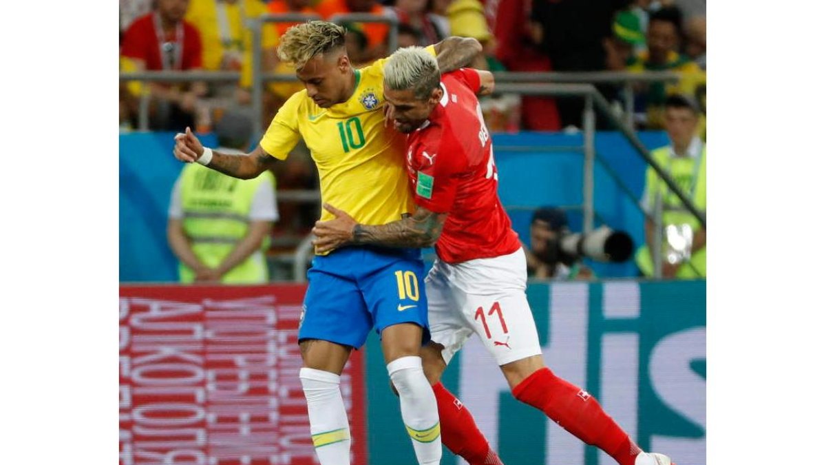El brasileño Neymar es frenado por el futbolista suizo Valon Behrami. SHAWN THEW