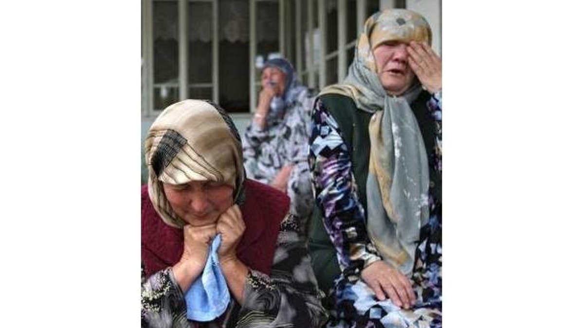 Dos mujeres lloran la pérdida de sus seres queridos.