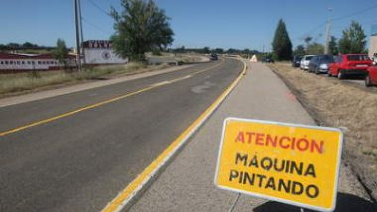 Un cartel advierte a los conductores de la presencia de máquinas trabajando al coronar el Alto de La