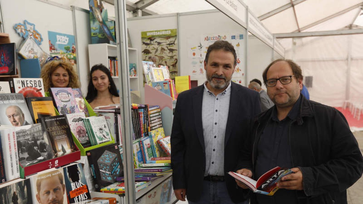 En la imagen de la izquierda, el concejal de Cultura y el alcalde de La Bañeza ayer en la Feria del Libro; en la derecha el stand del Diario de León. FERNANDO OTERO