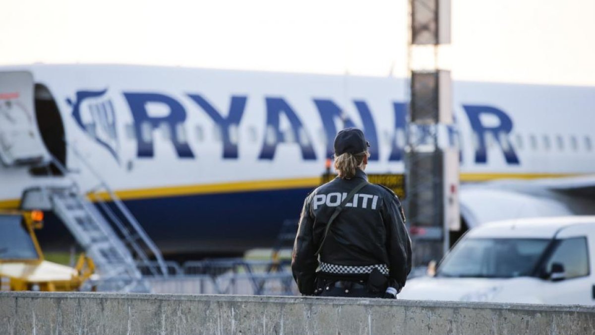 Un agente de policía, frente al avión de Ryanair evacuado, el domingo en el aeropuerto noruego de Moss-Rygge.