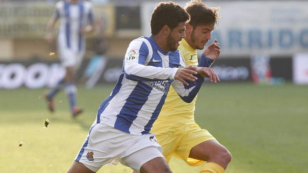 El jugador del Villarreal, Joan Riol, pugna en carrera con el delantero mexicano Carlos Vela.