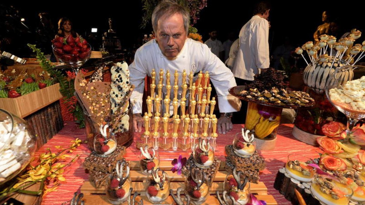El chef austriaco Wolfgang Puck posa junto a las estatuillas de chocolate que servirá en el Baile del Gobernador.