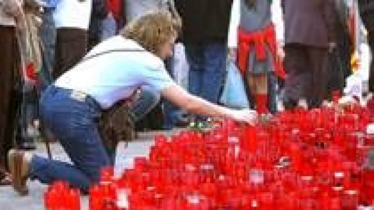 Una mujer enciende una vela en Chamartín por las víctimas del 11-M