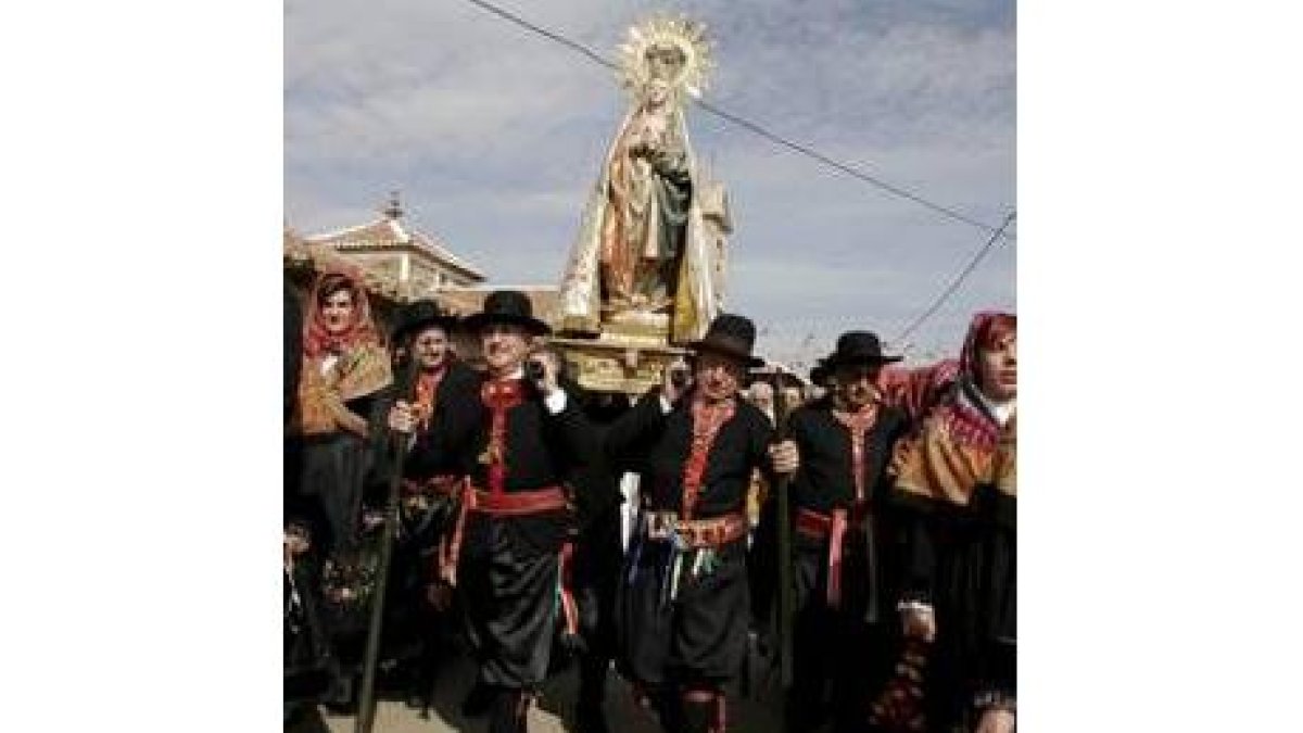 La Virgen de los Remedios (arriba), un niño desfilando (abajo) y los arco de flores de las jóvenes