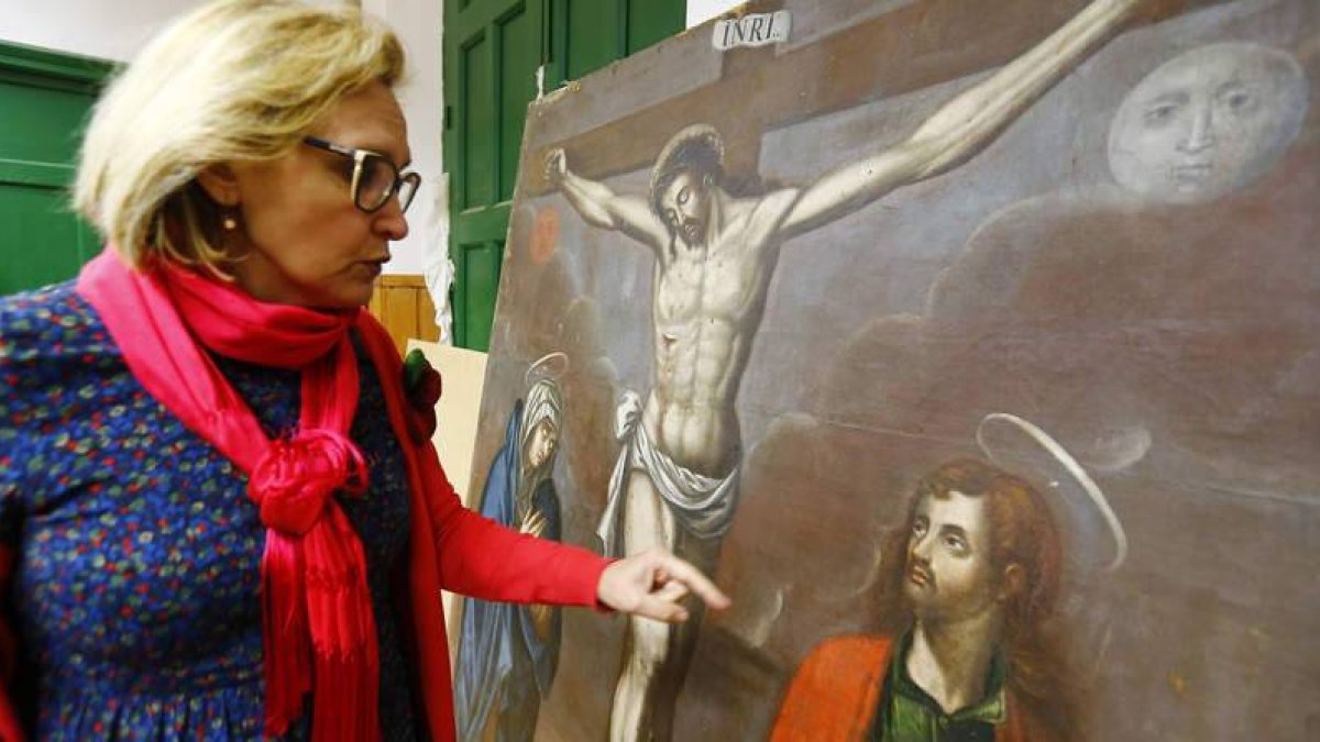 La restauradora Marta Eva Castellanos muestra la pintura barroca de San Pedro de los Oteros ya recuperada por completo.