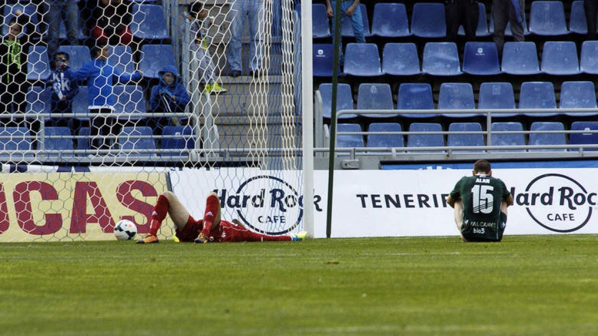 Santamaría y Alan Baró, en el suelo tras encajar el tercer tanto del Tenerife, son la viva imagen de la impotencia de la Deportiva ayer en el Heliodoro Rodríguez López.