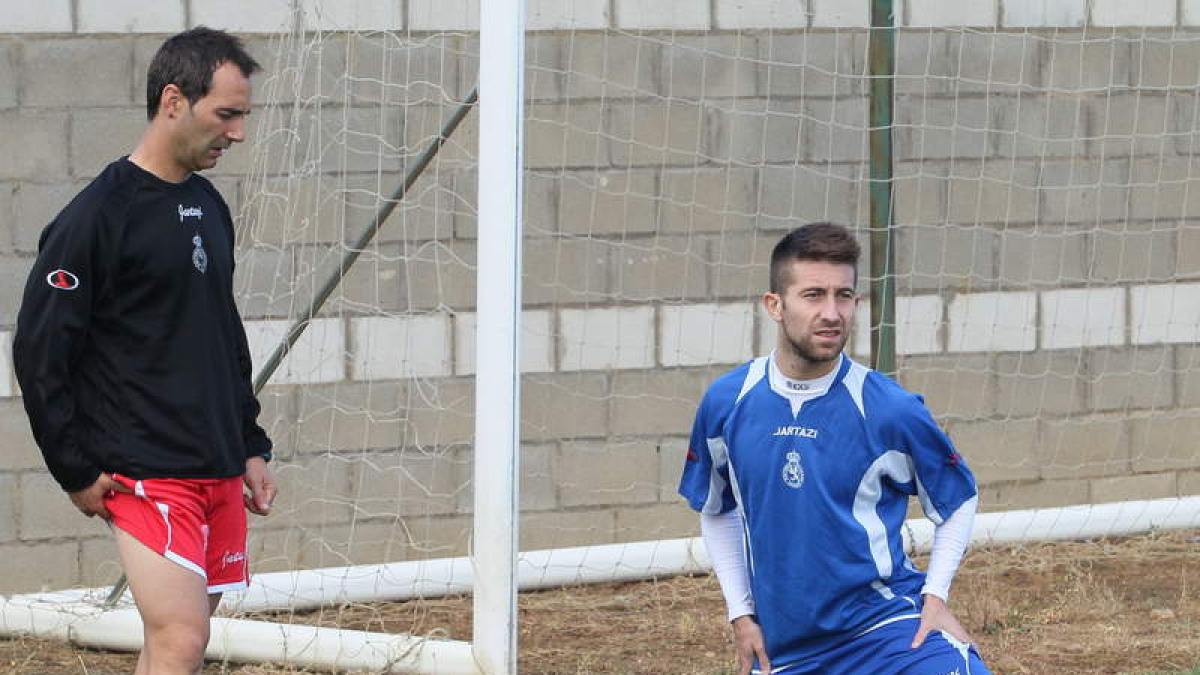 Jony Lomas, derecha, estira tras un entrenamiento.
