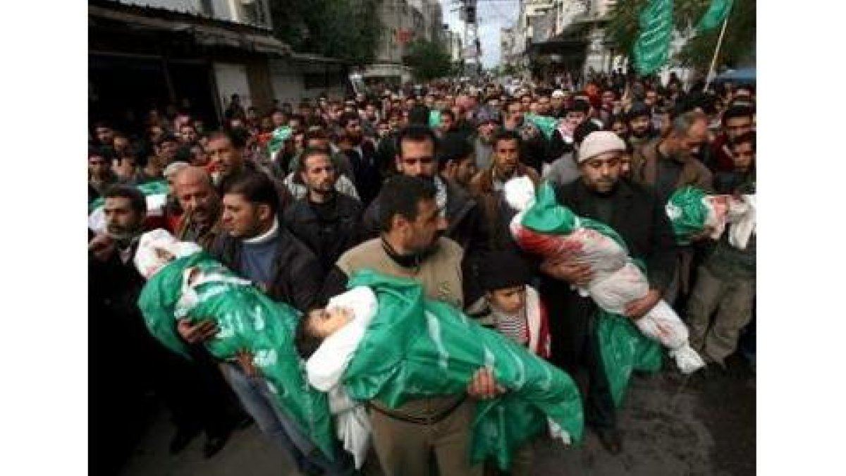 Miembros de Hamas llevan en brazos a los hijos de Nizar Rayan