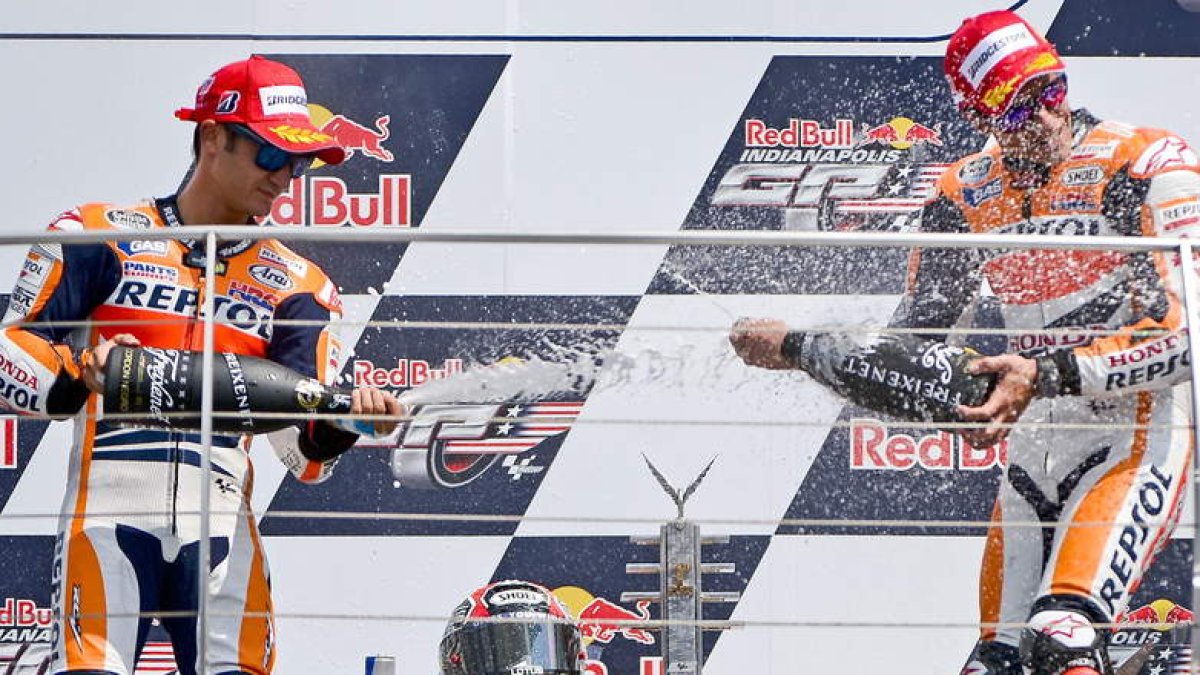 Marc Márquez, a la derecha, festeja la victoria con su compañero de equipo Pedrosa.