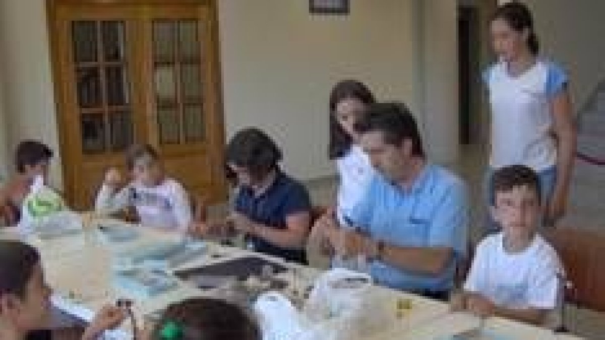 Niños y niñas participan en una clase de montaje de moscas artificiales