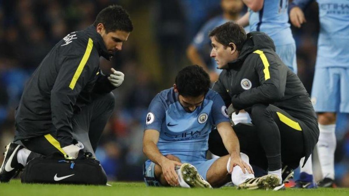 Gundogan se duele de la rodilla derecha mientras es atendido, durante el partido contra el Watford.