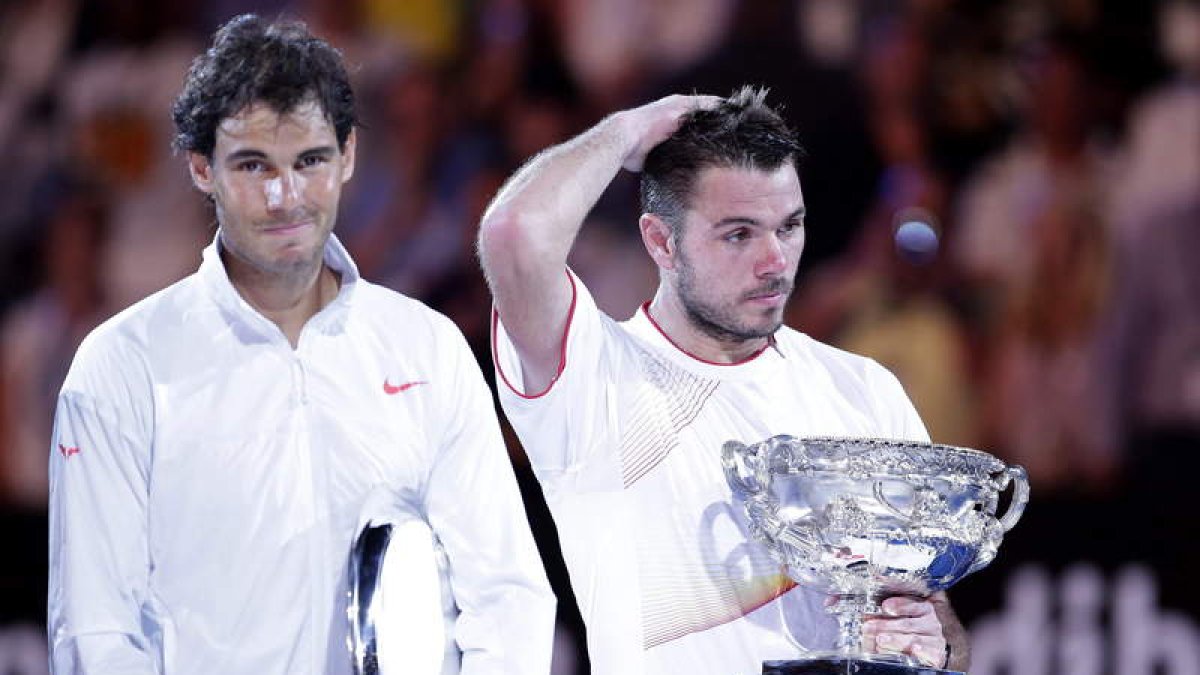 Nadal con gesto de triste con el trofeo de subcampeón al lado de un Wawrinka pensativo.