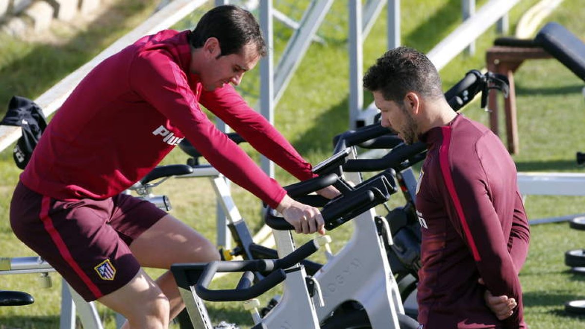 Godín y Simeone conversan durante el entrenamiento de ayer en El Cerro del Espino. MARISCAL