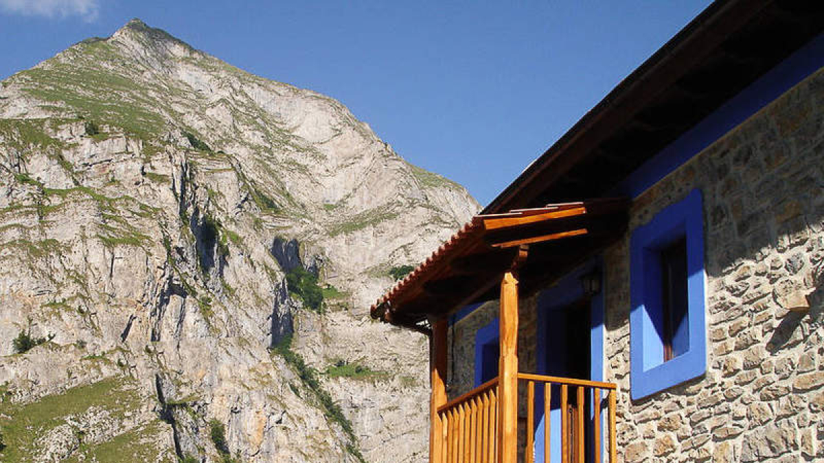 Exterior y dormitorio de la casa ruralLa Sierra en Ribota de Sajambre.