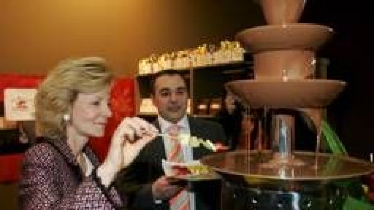 Elena Salgado prueba una brocheta de frutas mojadas en chocolate durante la presentación