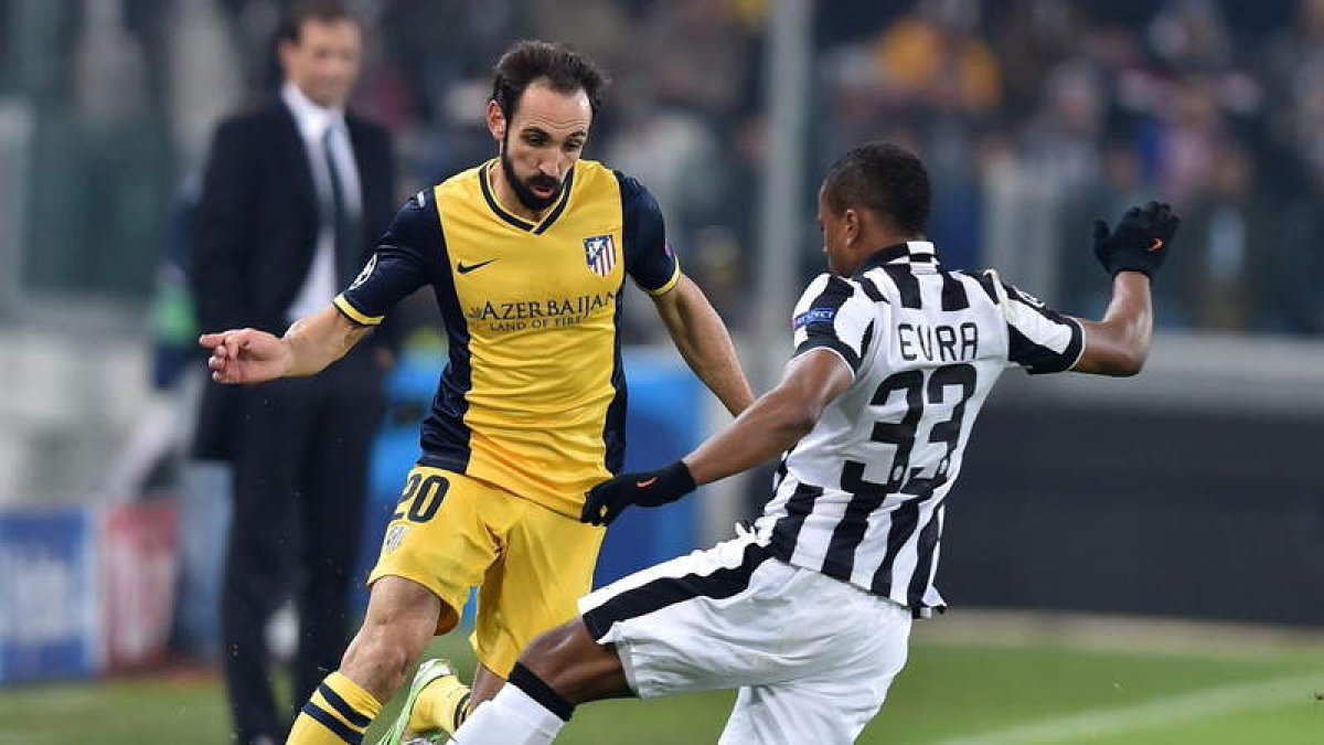 Patrice Evra pelea por el control del balón con el defensa del Atlético Juanfran Torres.