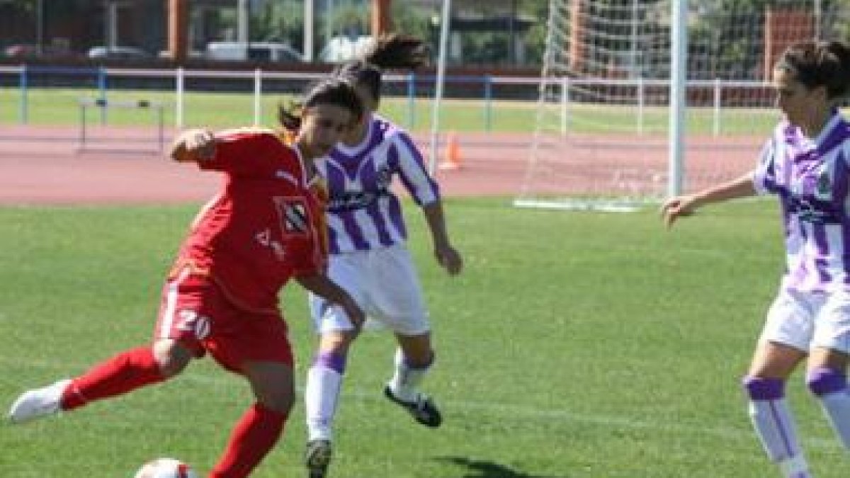 María se lleva el balón ante dos contrarias ayer.
