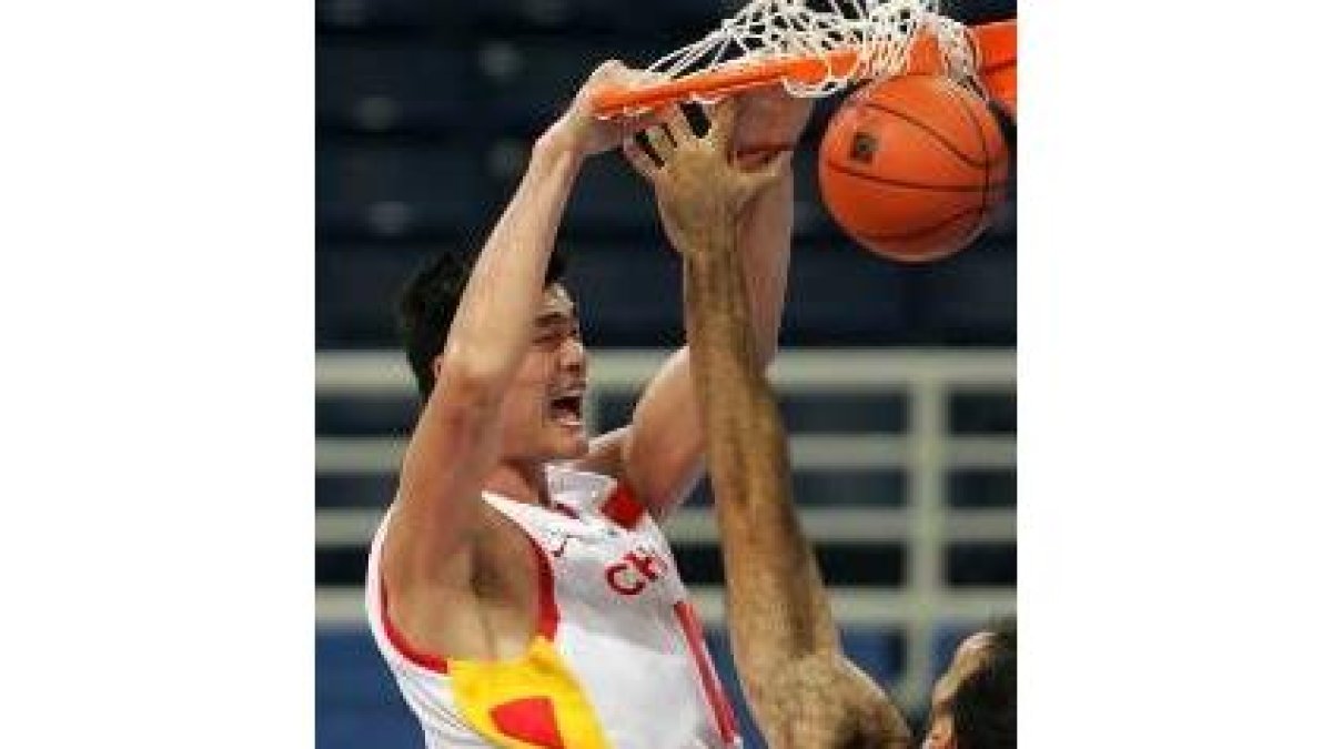 Dueñas observa cómo el gigante chino Yao Ming machaca la canasta del equipo español