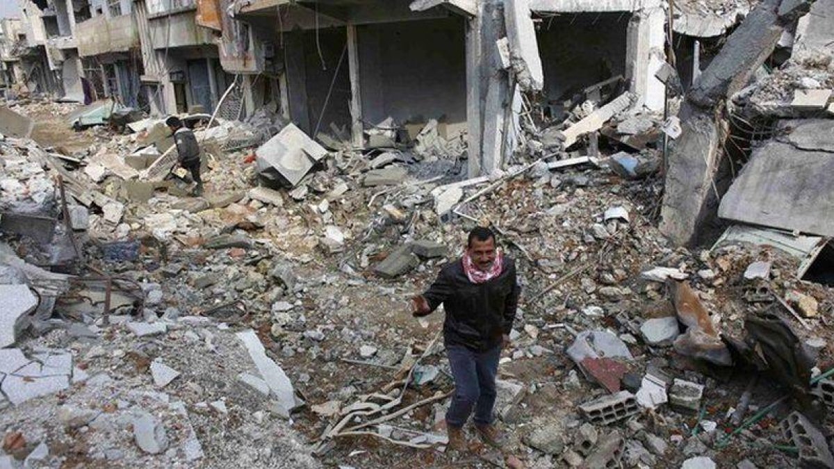 Hombres kurdos caminan entre los escombros en la parte norte de Kobani.