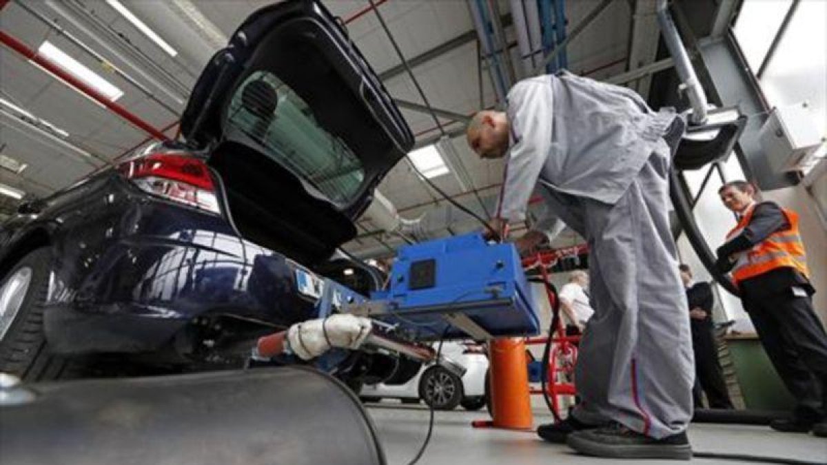 Un técnico utiliza un sistema de medición de emisiones con un modelo Citroen C4.