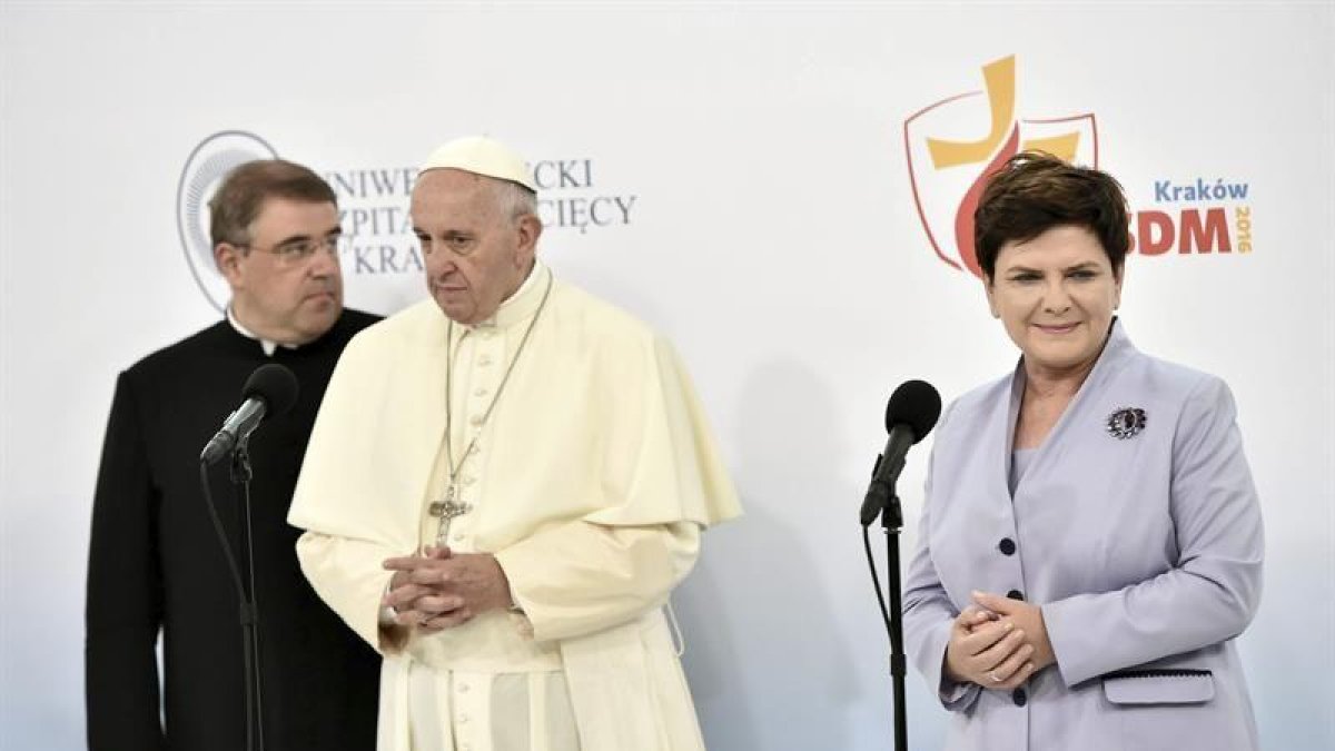 La primera ministra polaca, Beata Szydlo (d), el sacerdote Robert Wozniak (i) y el papa Francisco (c) durante una visita a un hospital universitario infantil de Prokocim (Cracovia).