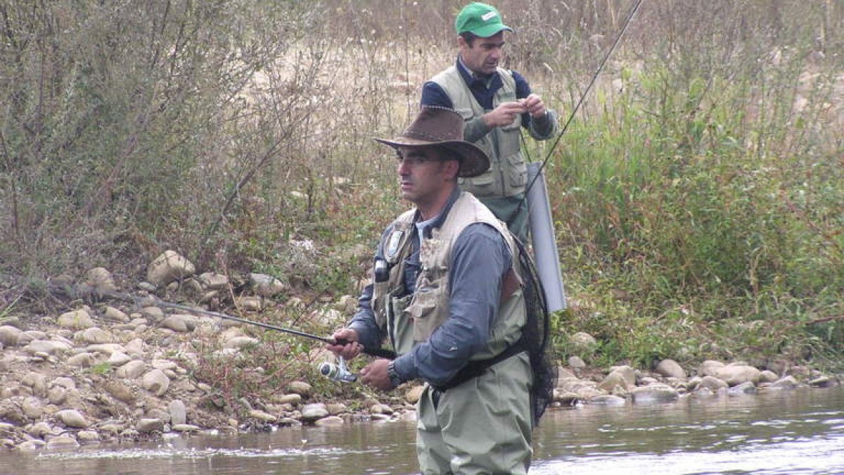 Dos pescadores en plena temporada en un río de la provincia.