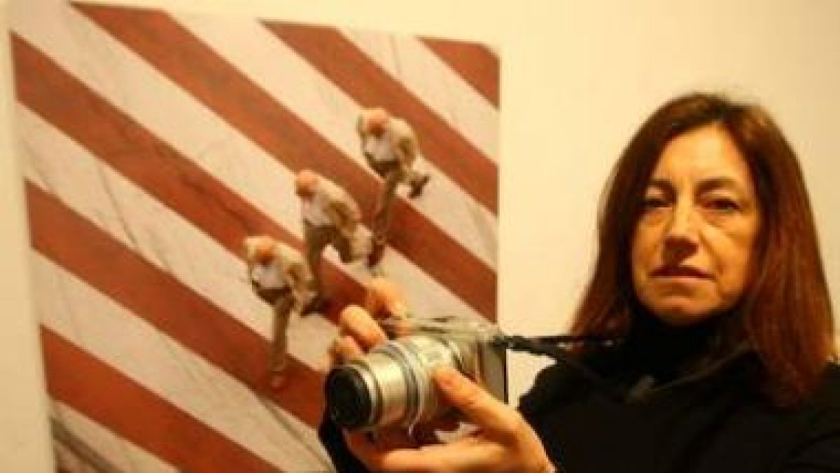 Esther Santás, con su cámara, ante una de las imágenes de la muestra del campus.