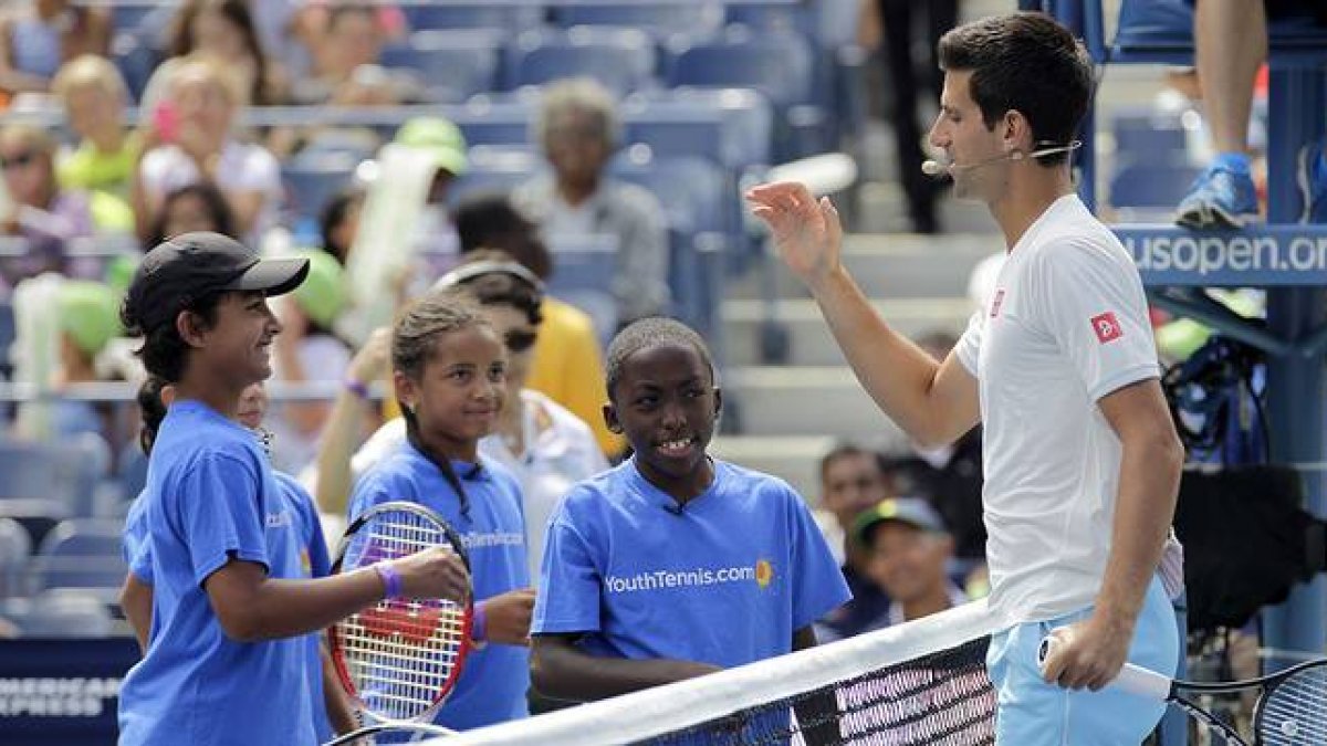 Novak Djokovic saluda a unos niños en la pista Arthur Ashe de Flushing Meadows.