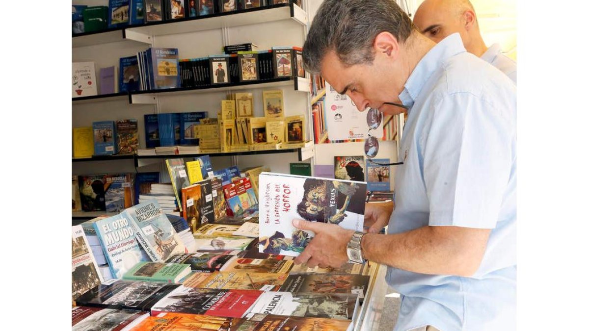 Casetas con libros leoneses y José Luis Puerto, debajo, en una conferencia