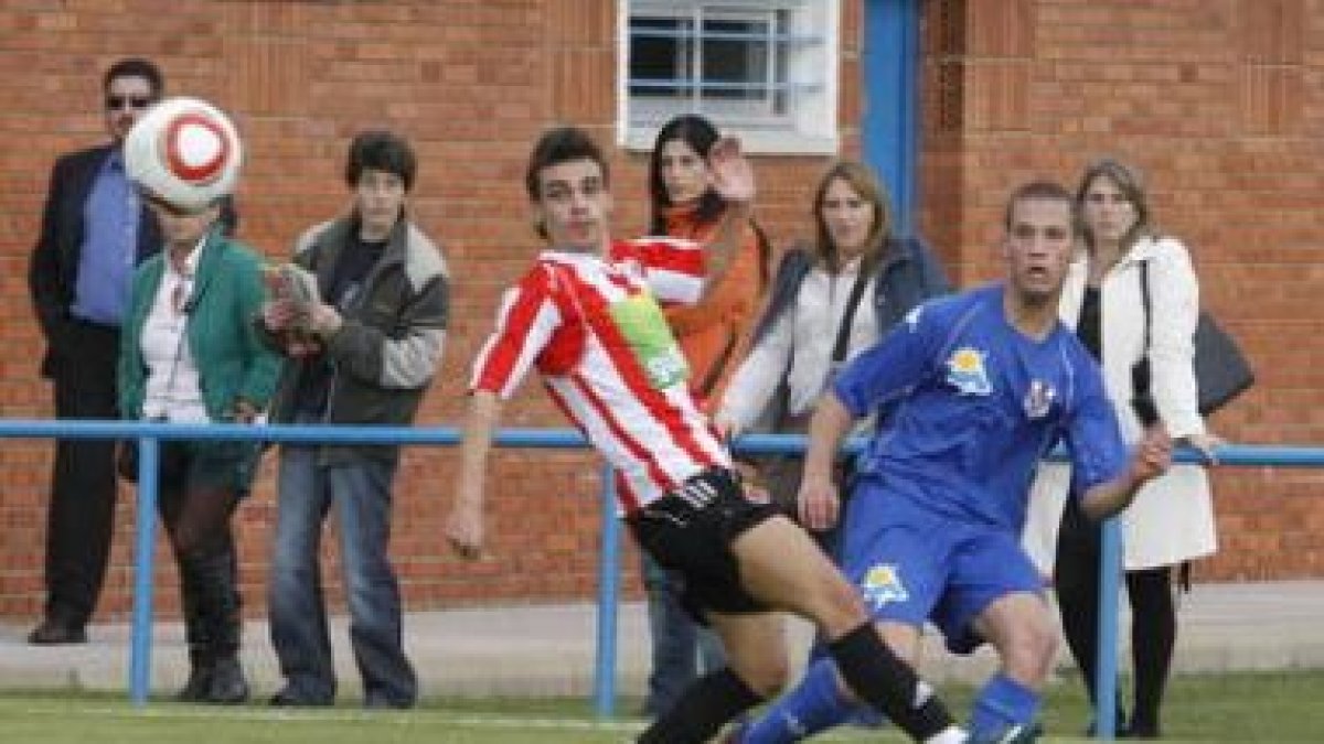 Fernando, a la derecha, despeja el balón a pesar de la oposición de un contrario.