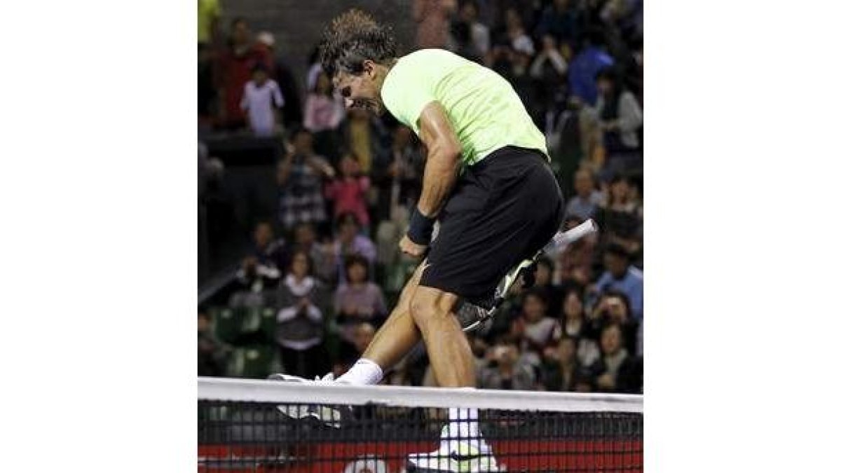 Nadal celebra su triunfo en Tokio saltando soble la red.