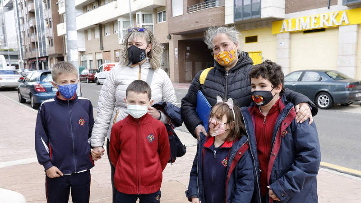 Fátima González, con Germán y Marcos, y Olga Rejas, con Sara y Guillermo, ayer a la salida del colegio, en La Chantría. M. PÉREZ