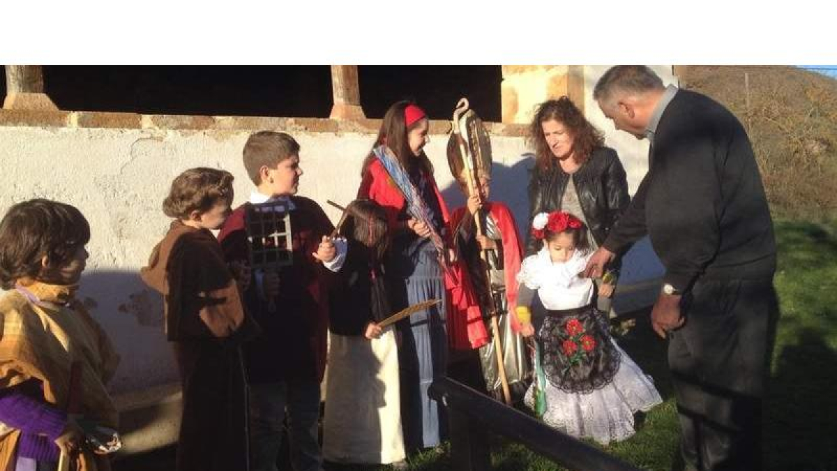 El párroco estaba con los niños disfrazados de santos y santas junto a la iglesia.