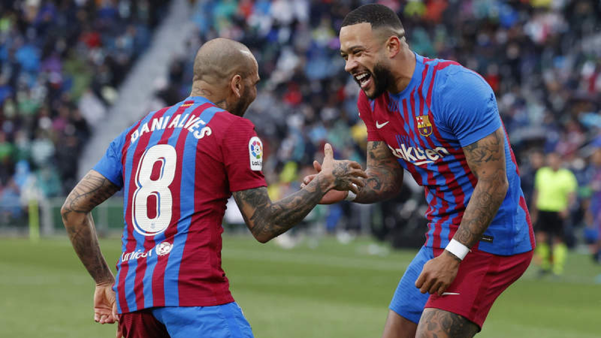 El delantero neerlandés del Barcelona Memphis Depay celebra con Dani Alves el gol de penalti que valió la victoria. BIEL ALIÑO