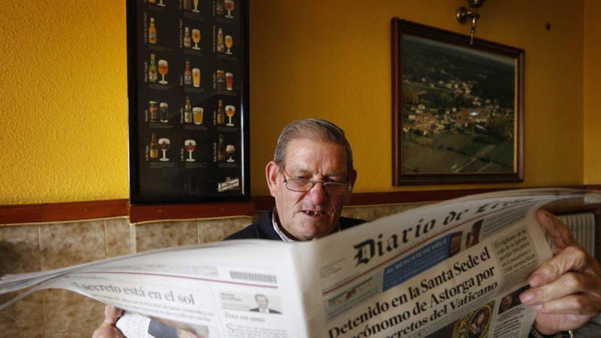 Un vecino de Vega de Magaz lee en el bar la noticia de la detención de su ex párroco.