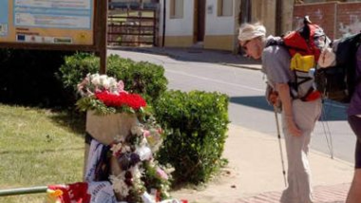 Una peregrina contempla el lugar, lleno de recuerdos, donde falleció el joven.
