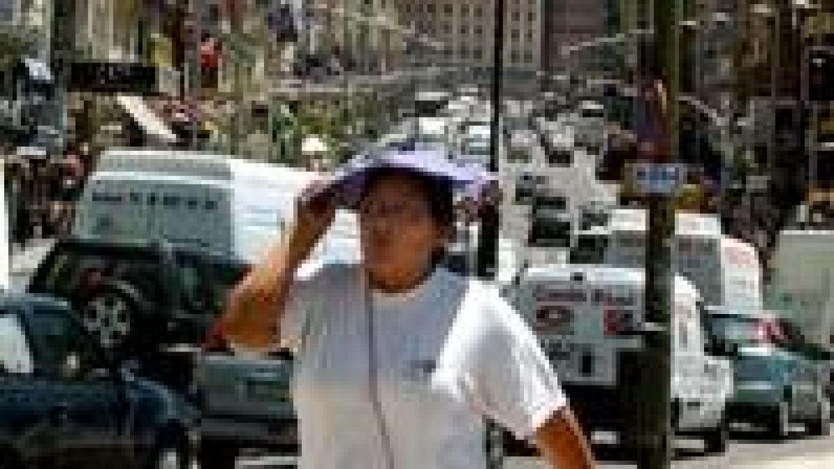 Una mujer se tapa la cabeza ante el sofocante calor de los últimos días